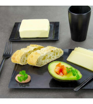 Gedeckter Frühstückstisch mit dekoriertem Marmorteller und schwarzer Butterdose mit Butter geöffnet