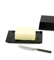 Black wooden butter dish with butter and butter knife