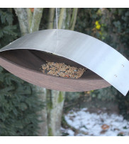 Modern birdhouse for hanging made of oak smoked with stainless steel roof filled with bird food