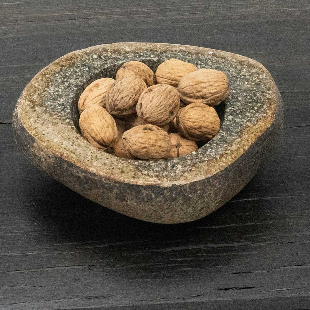 Decorative bowl made of stone in stone beige color decorated with walnuts