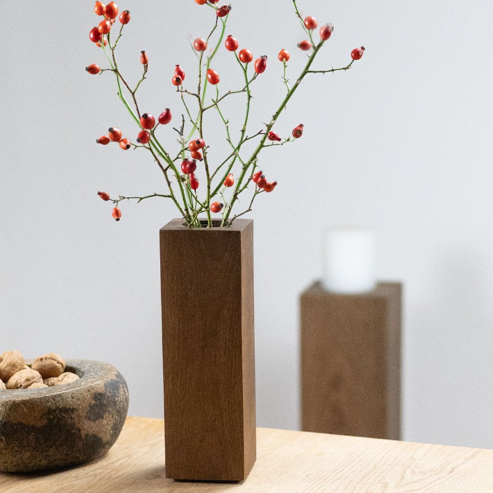 COLUMN 25 wooden vase made of smoked oak decorated with rosehip branches and stone bowl